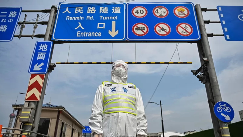 一名身穿防护服的上海交管控制进入浦东区方向的隧道入口